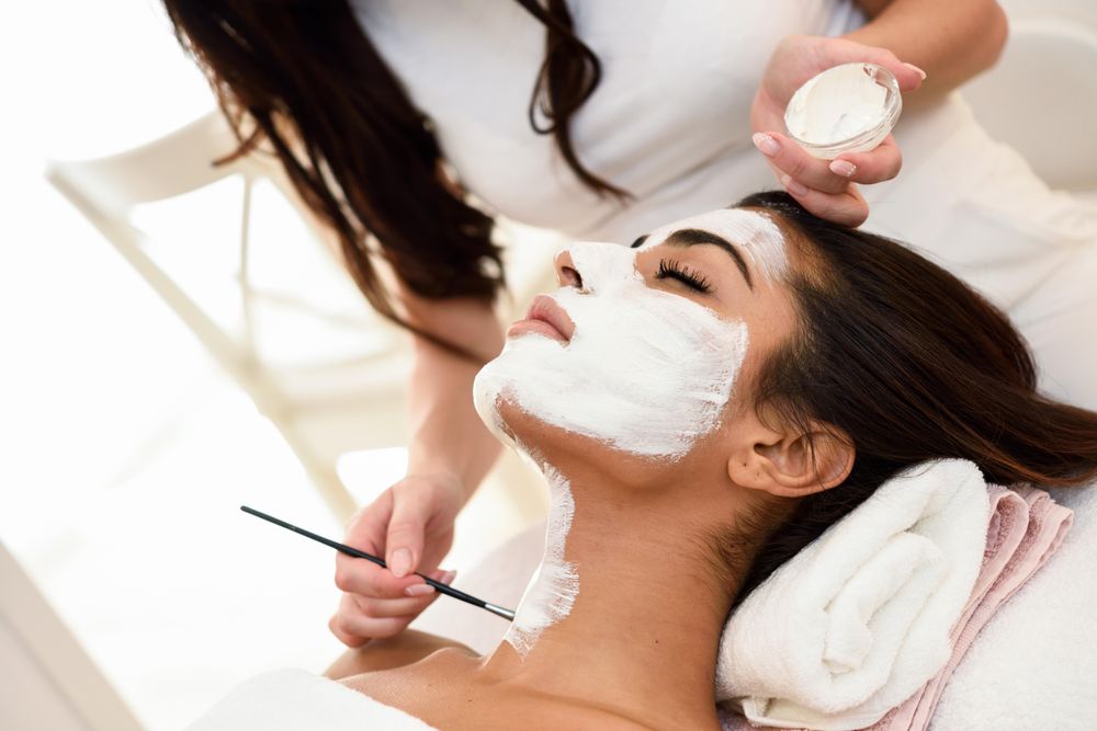 Woman applying product to client’s neck with a brush