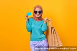 Muslim woman smiling with shopping bags and credit card 5peeA4