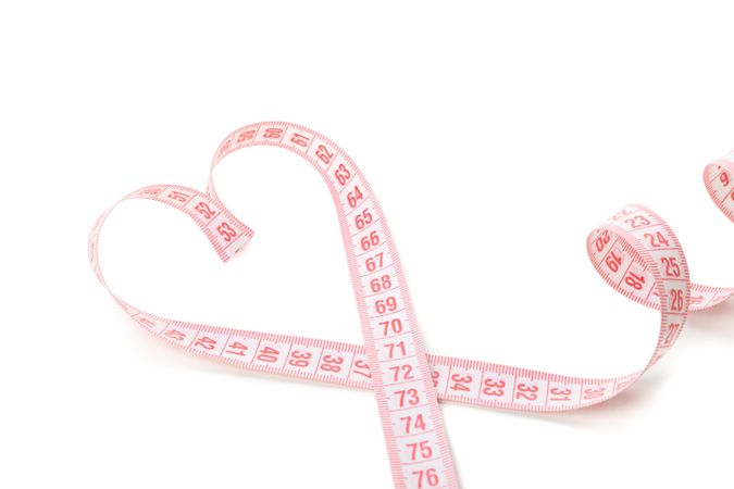 Measuring tape in the form of heart isolated on blank background