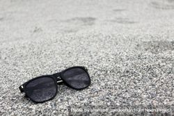 Sunglasses sitting on grey pebbles 4NDDA0