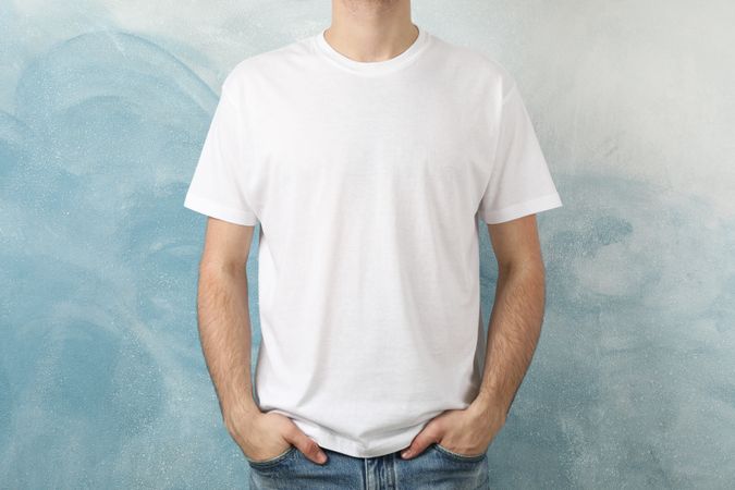 Men in blank t-shirt against blue background, space for text