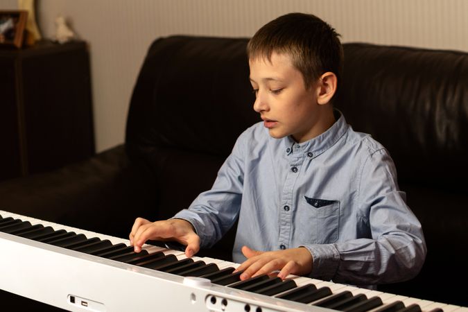 Boy concentrating while playing the keyboard