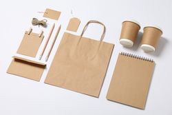 Composition with blank stationery, paper cups and bag on blank background, mockup