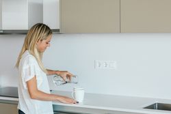 Woman making tea in kitchen