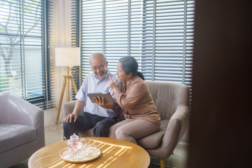 Asian mature couple watching or video call with family on tablet