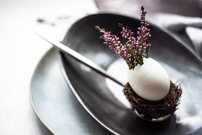 Elegant Easter table with heather and egg decor on dark plate