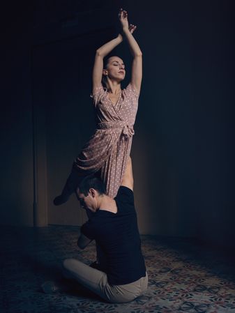 Graceful woman lifted by male in darkness