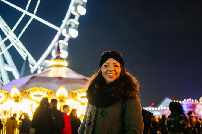 Happy woman on fairground at night
