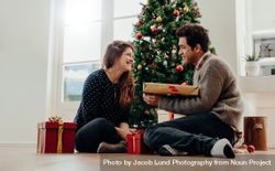 Man and woman exchanging Christmas gifts at home 4MGl1l