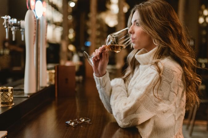 Stylish woman drinking wine in bar