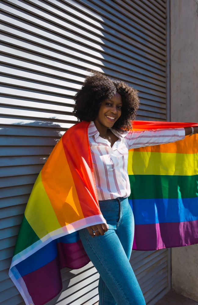 Woman posing happily with the LGBT flag
