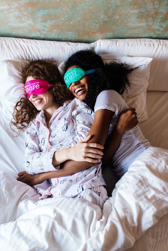 Friends relaxed sleeping in bed with blindfold at home