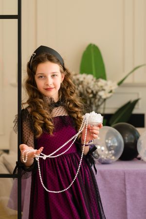 Girl holding pearls and smiling