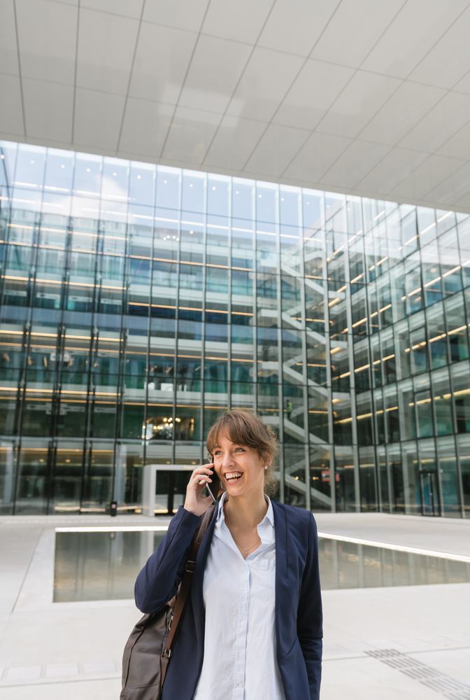 Smiling entrepreneur browsing smartphone outside office building