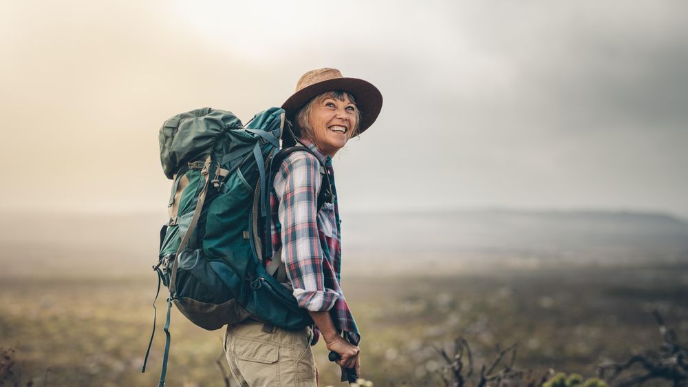 Female hiker enjoying the view standing on a hill