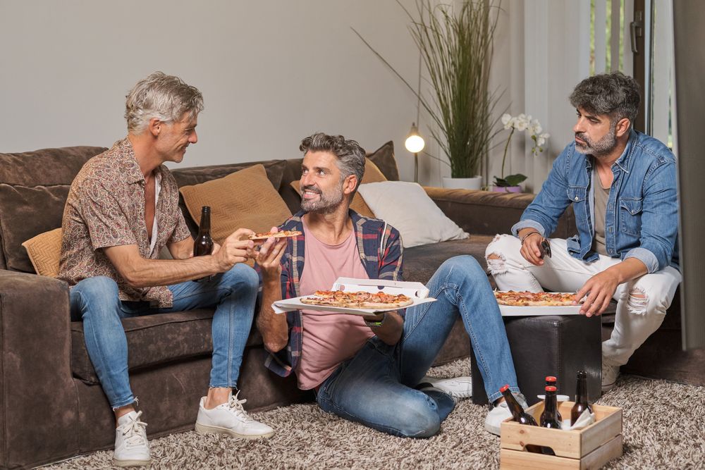 Group of friends eating pizza at home