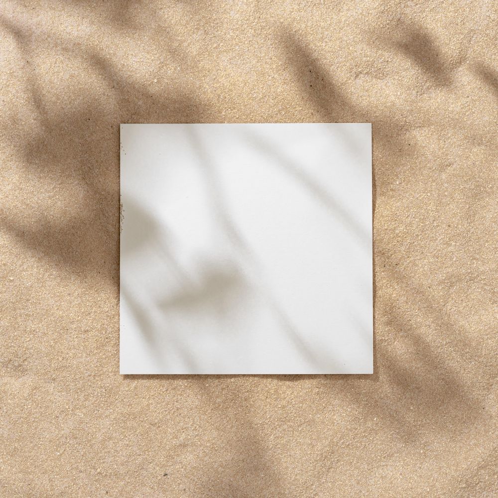 Sand with palm leaf shadows and central square