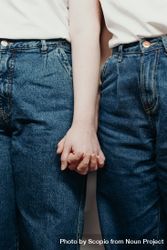 Two people in blue denim jeans holding hands bDmvK0