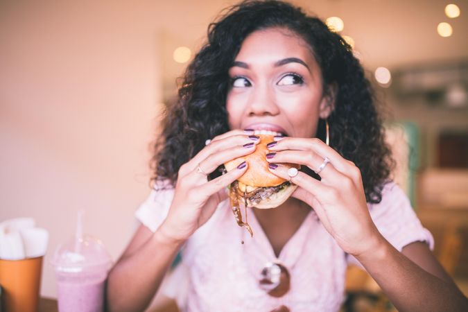 Young woman taking a bite of a hamburger
