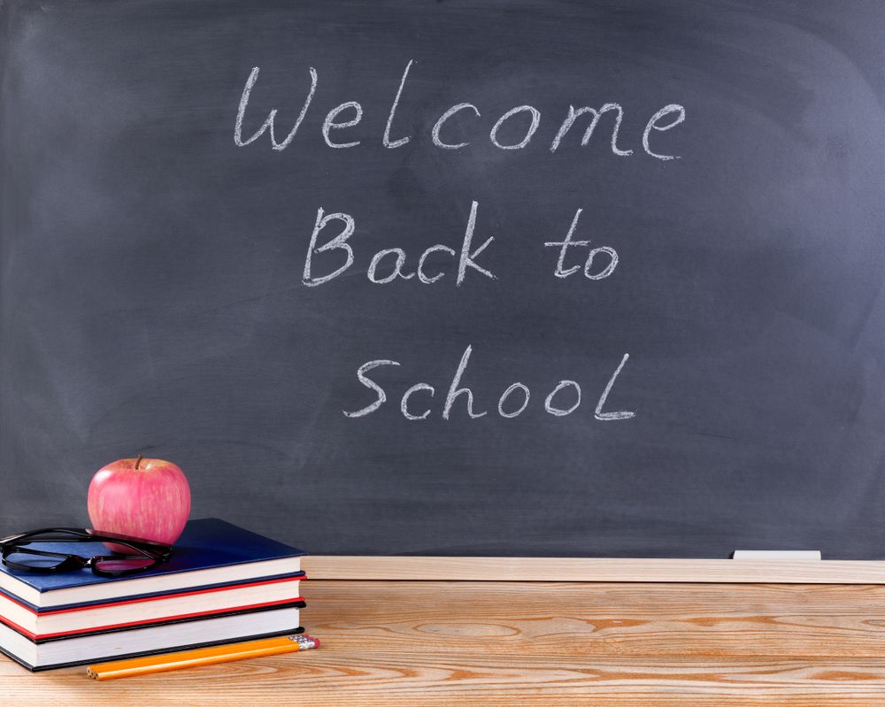 Student desktop and erased chalkboard with welcome back to school message
