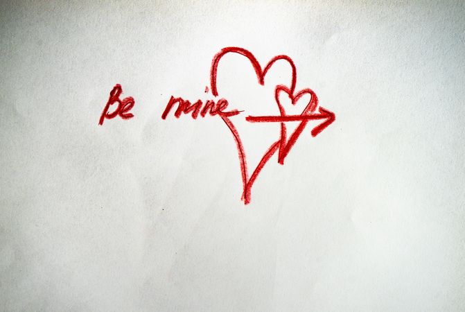 Valentine Day holiday card concept with "Be Mine" and heart scribbled on paper
