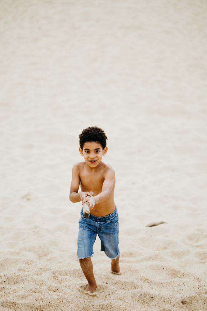 Black boy playing on beach