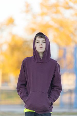 Portrait of a young male teen in red hood outdoors