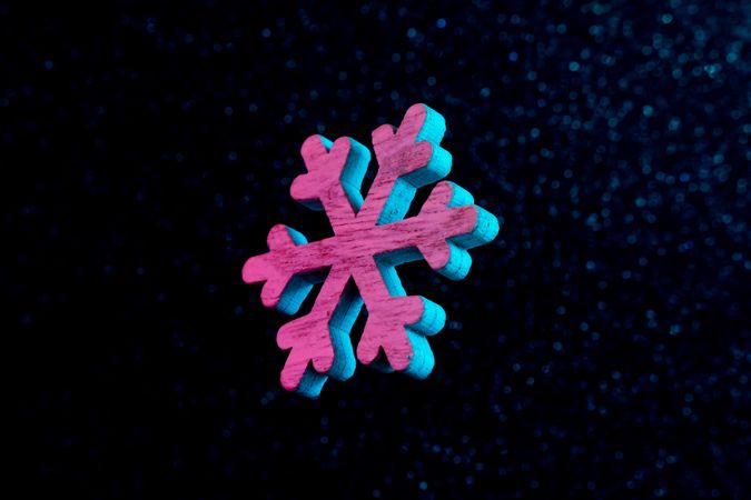 Snowflake in vivid neon colors on dark  background