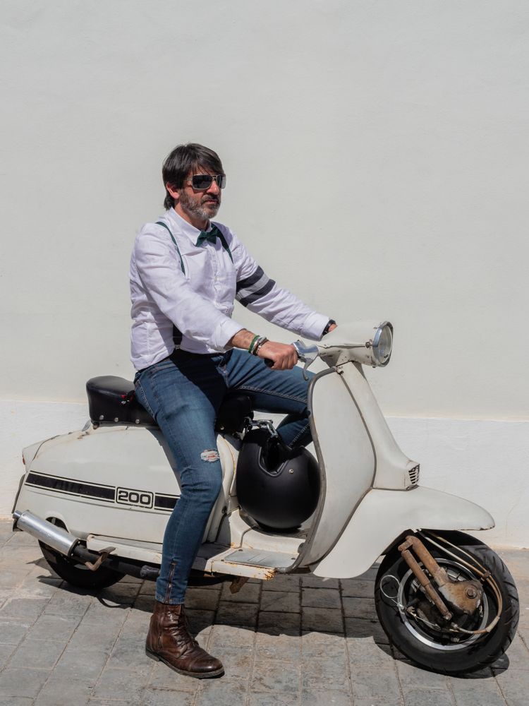 Trendy man sitting on vintage scooter