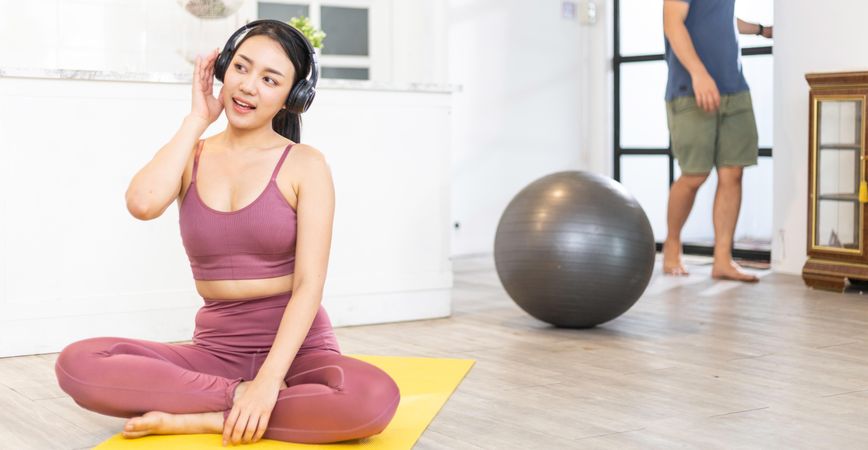 Asian woman in sportswear listening to music with headphone