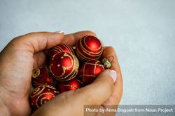 Christmas scene of hand holding red baubles 0JpOr4