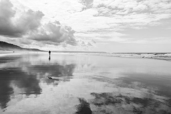 Person walking along the coast on cloudy day