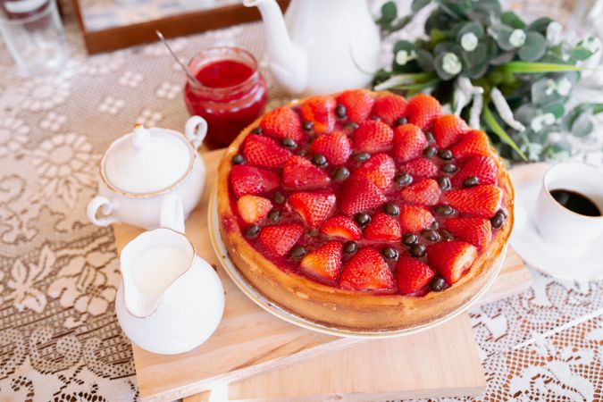 from above a strawberries cake on table with coffee and milk