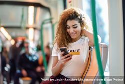 Arab woman sitting in train carriage texting on phone 0P7X2b