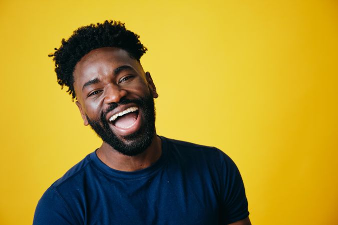 Portrait of joyful Black man on yellow background