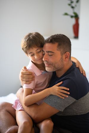 Little girl and dad hugging each other at home