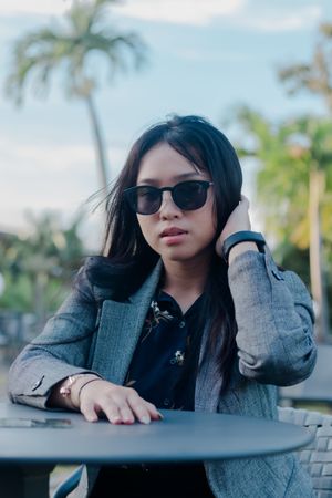 Stylish woman portrait in the tropical setting with gray blazer