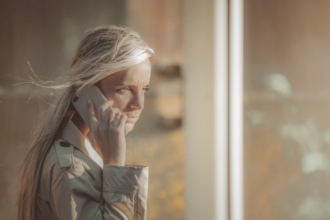 Traveling woman speaking on the phone near an airport