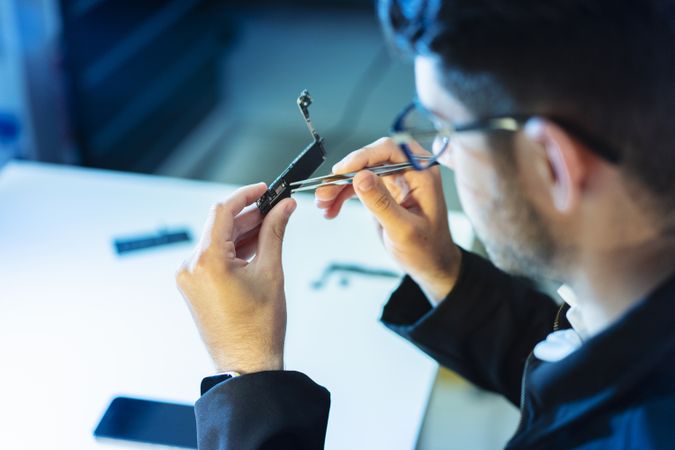Young man repairing modern device