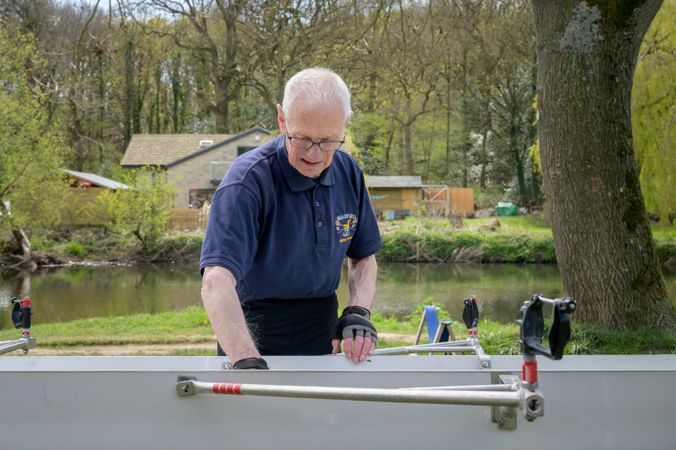 Man preparing boat for rowing near river