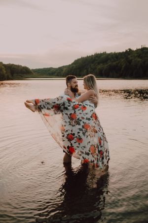 Loving couple standing ankle deep in water on beach