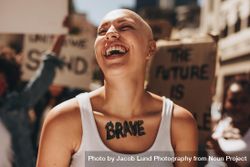 Bald woman laughing outdoors during a protest 4ZpR10