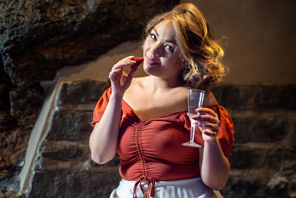 Coy woman with glass of champagne and strawberry