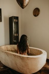 Woman sitting and washing in bath