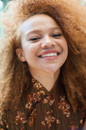 Close up portrait of young woman with afro smiling at the camera