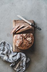 Freshly baked sourdough bread loaf, sliced, vertical composition, copy space