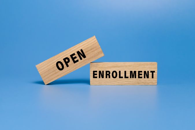 open enrollment words on wooden blocks isolated on blue background