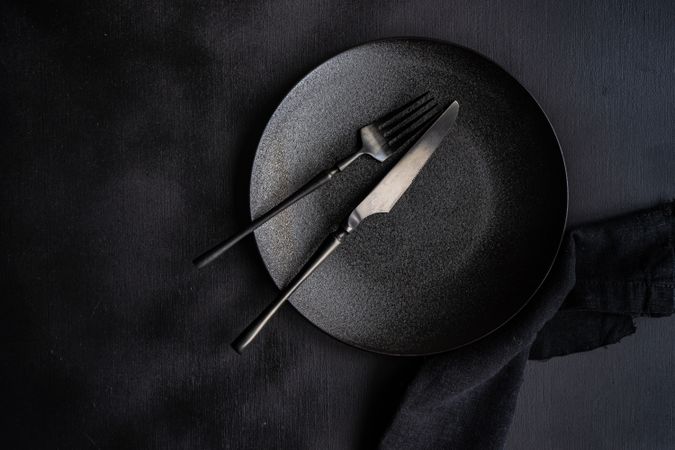 Table setting with dark plate, napkin and cutlery