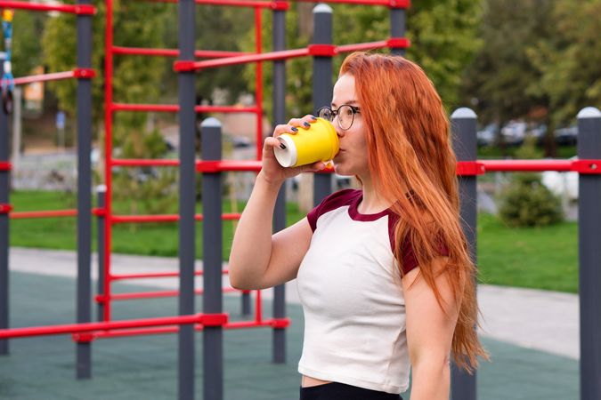 Woman drinking from yellow cup during break