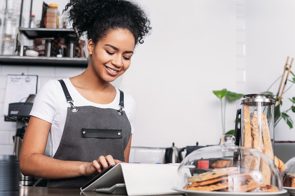 Barista taking order on digital tablet in cafe